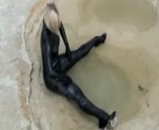 Super Hot Blond Girl In Black Latex Catsuit + High Heels And Sunglasses Bathes In The Mud - Mud Bath from boue